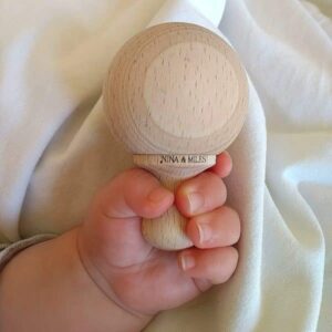 mini maracas en bois tenue par la main d'un bebe